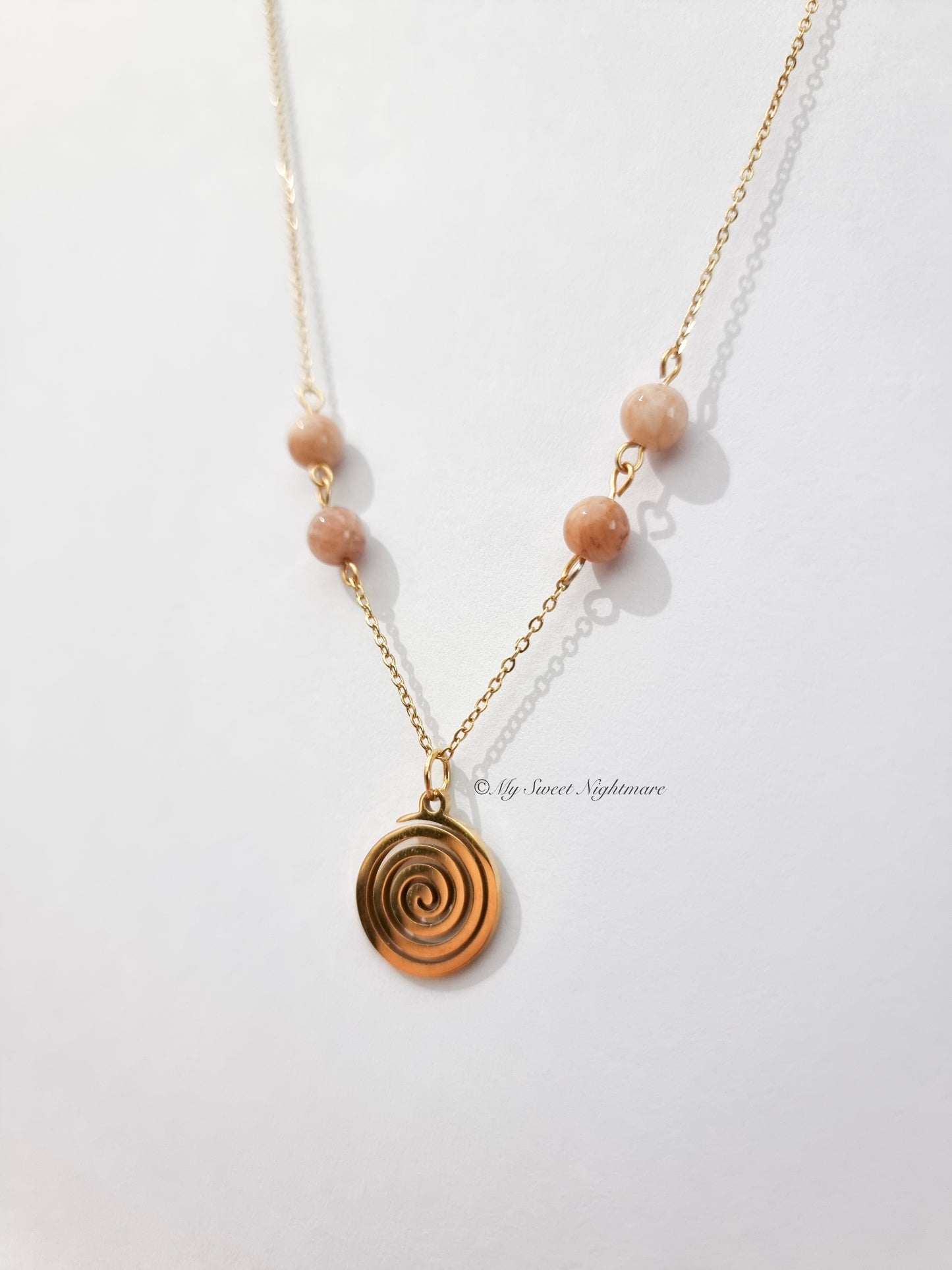 Collana con spirale dorata in acciaio e Pietra del Sole